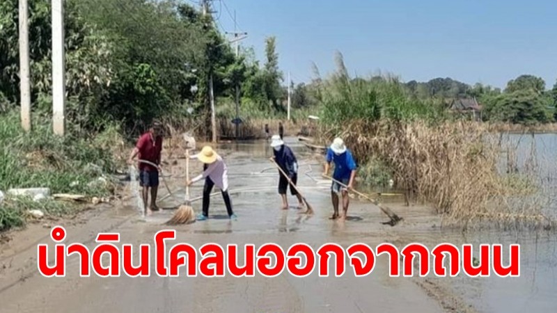 น้ำท่วมเริ่มลด ชาวบ้านช่วยกันนำดินโคลนออกจากผิวถนน  